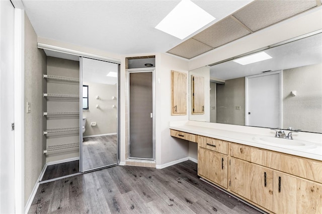 bathroom with wood-type flooring, vanity, and an enclosed shower