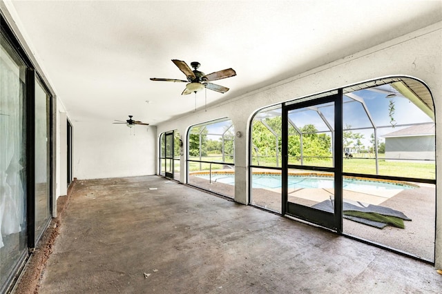 interior space featuring ceiling fan, concrete floors, and a healthy amount of sunlight