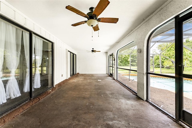 unfurnished sunroom featuring ceiling fan