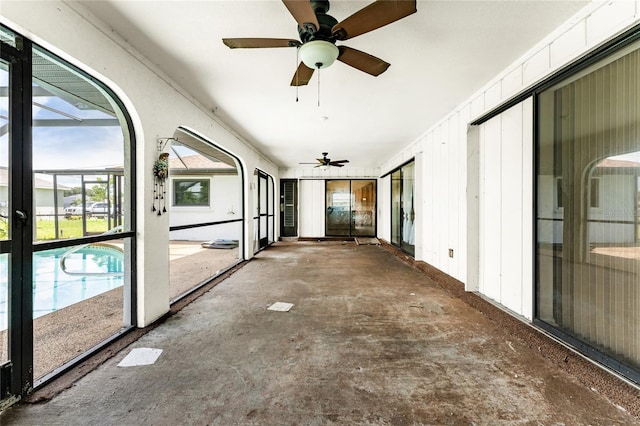 unfurnished sunroom featuring ceiling fan