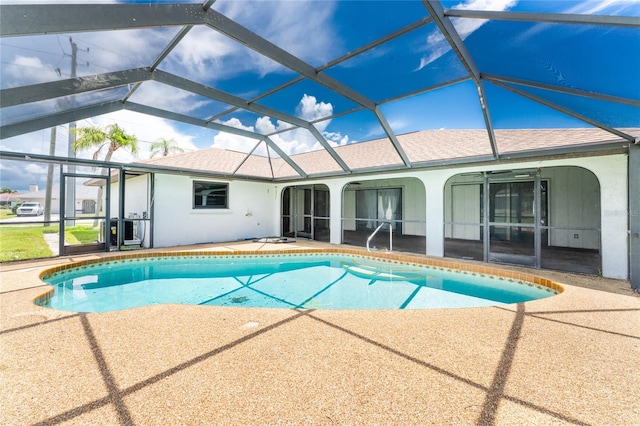 view of swimming pool with glass enclosure and a patio area