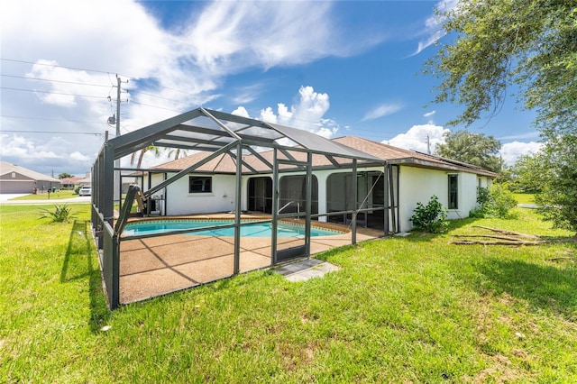 rear view of property featuring glass enclosure, a patio area, and a yard