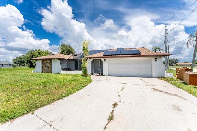 ranch-style house with a front yard, solar panels, and a garage