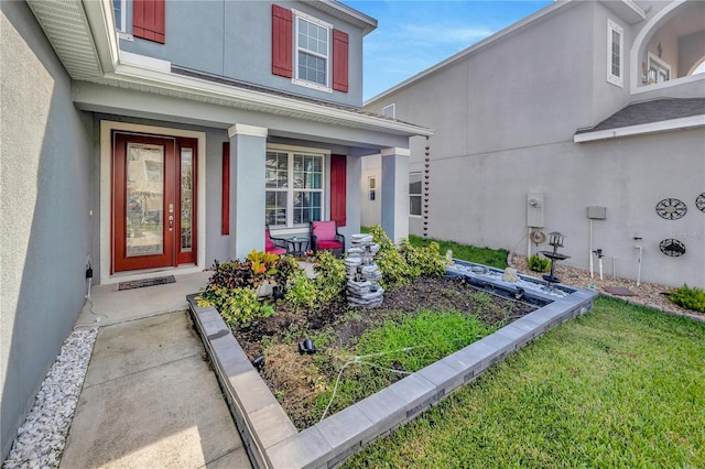 entrance to property with a lawn and a porch