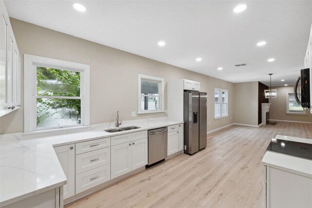 kitchen with white cabinetry, sink, appliances with stainless steel finishes, and light hardwood / wood-style flooring