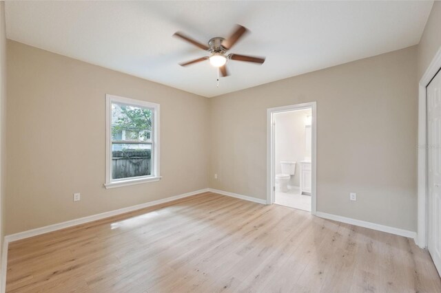 unfurnished bedroom featuring ceiling fan, ensuite bathroom, and light hardwood / wood-style floors