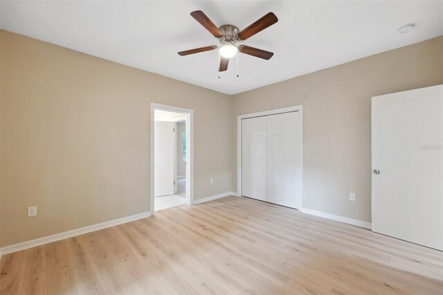 unfurnished bedroom featuring ceiling fan, a closet, and light wood-type flooring