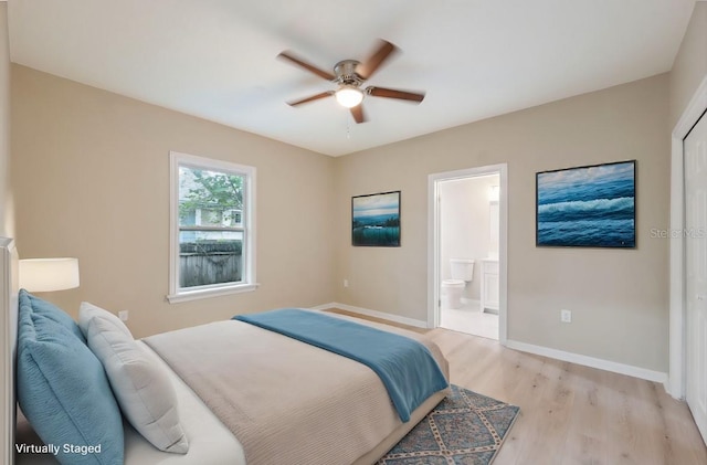 bedroom featuring light hardwood / wood-style floors, ceiling fan, and ensuite bathroom