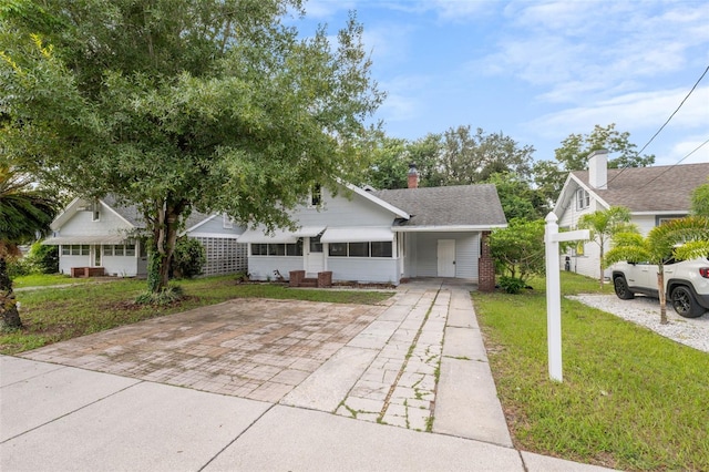 view of front of property featuring a carport and a front lawn