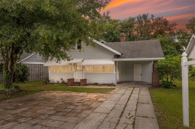 view of front of house with a carport and a yard