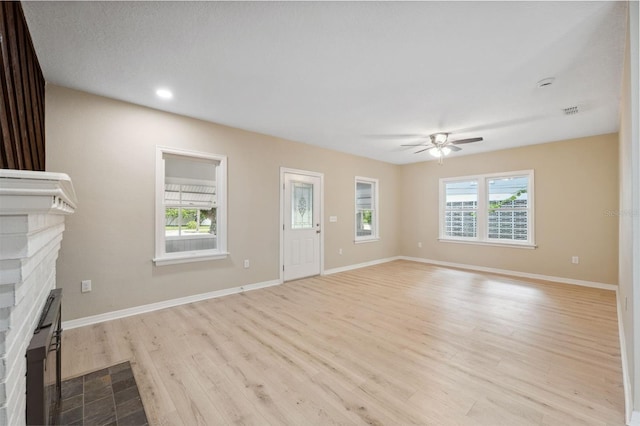 unfurnished living room featuring light wood-type flooring and ceiling fan