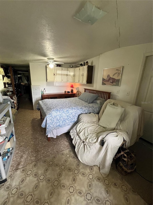 carpeted bedroom with a textured ceiling and ceiling fan