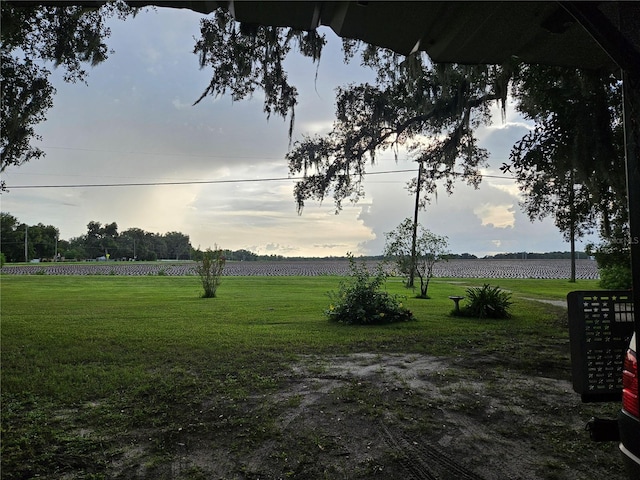 yard at dusk featuring a rural view