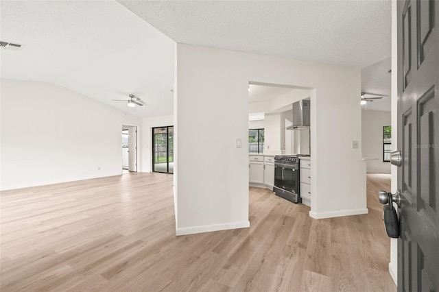 unfurnished living room featuring ceiling fan, lofted ceiling, and light hardwood / wood-style floors