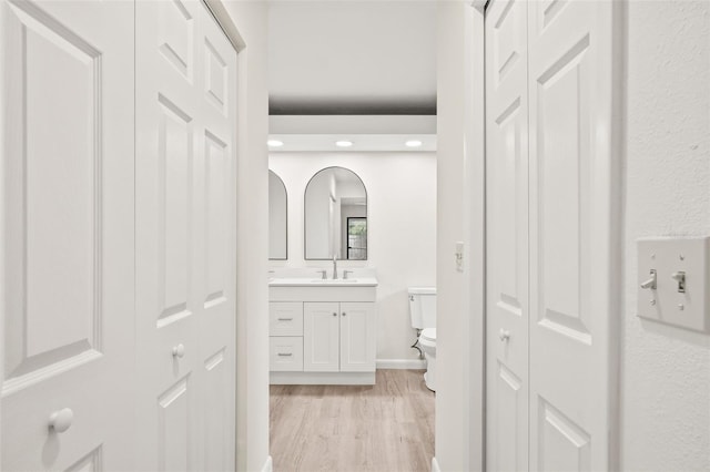 bathroom with hardwood / wood-style flooring, vanity, and toilet