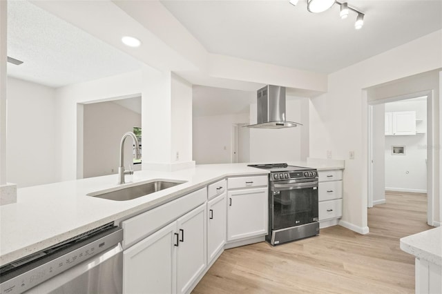 kitchen featuring light wood-type flooring, stainless steel appliances, white cabinetry, sink, and wall chimney exhaust hood