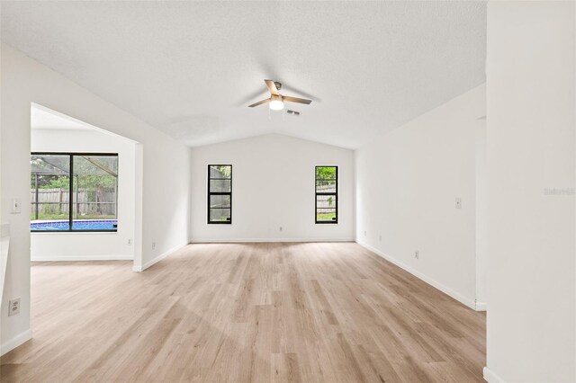 spare room featuring light hardwood / wood-style flooring, lofted ceiling, and ceiling fan