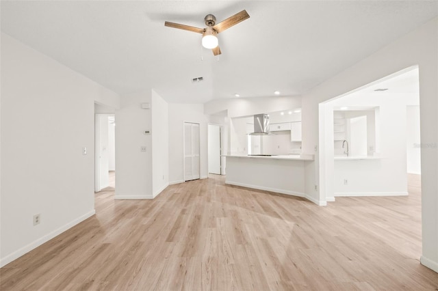 unfurnished living room with ceiling fan and light hardwood / wood-style flooring