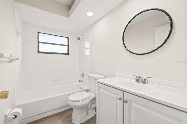 full bathroom with vanity,  shower combination, toilet, and hardwood / wood-style floors