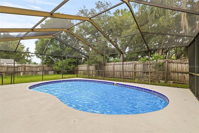 view of swimming pool with glass enclosure and a patio area