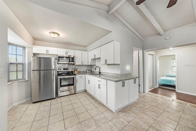 kitchen with lofted ceiling with beams, ceiling fan, light wood-type flooring, stainless steel appliances, and sink