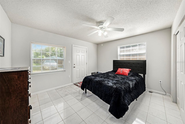 tiled bedroom featuring ceiling fan and a textured ceiling