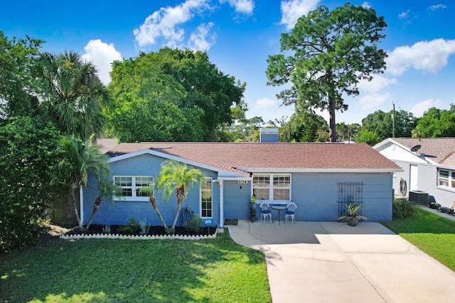 ranch-style home with a front yard and central AC unit