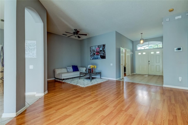 unfurnished living room featuring a textured ceiling, ceiling fan, and light hardwood / wood-style floors