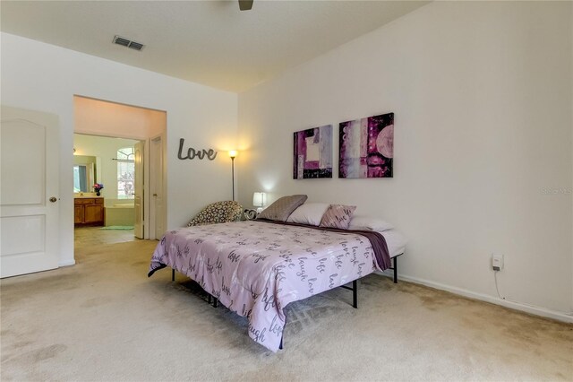 carpeted bedroom with ceiling fan and ensuite bathroom