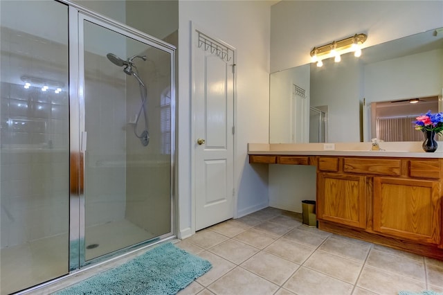 bathroom with walk in shower, vanity, and tile patterned flooring