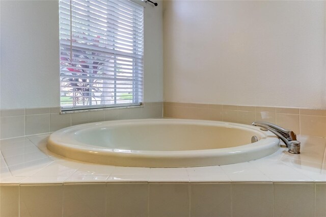 bathroom with a relaxing tiled tub