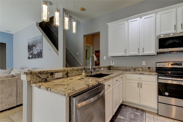 25954 Risen Star Dr, Wesley Chapel, FL 33544 - kitchen featuring sink, appliances with stainless steel finishes, white cabinetry, decorative light fixtures, and kitchen peninsula