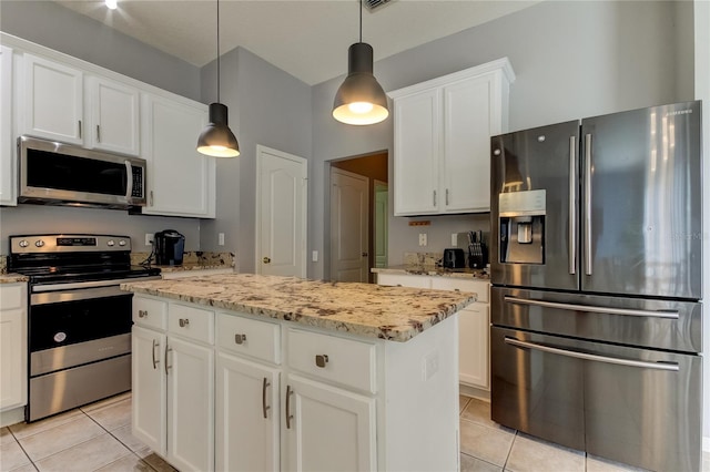 25954 Risen Star Dr, Wesley Chapel, FL 33544 - kitchen with decorative light fixtures, a center island, light tile patterned floors, appliances with stainless steel finishes, and white cabinets