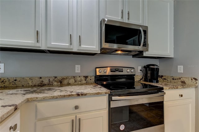 kitchen with white cabinets, stainless steel appliances, and light stone countertops