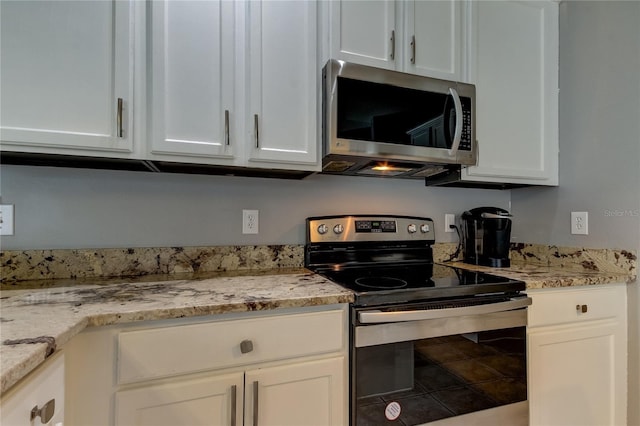 25954 Risen Star Dr, Wesley Chapel, FL 33544 - kitchen featuring light stone countertops, white cabinetry, and appliances with stainless steel finishes