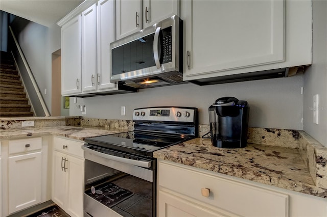 kitchen featuring light stone countertops, appliances with stainless steel finishes, and white cabinetry