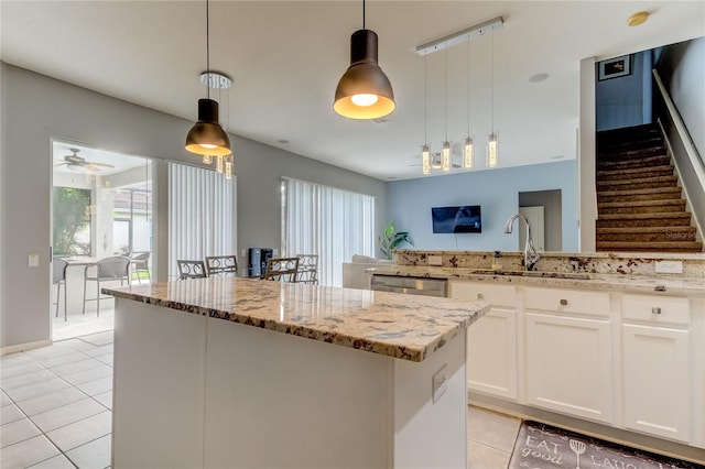25954 Risen Star Dr, Wesley Chapel, FL 33544 - kitchen with a center island, pendant lighting, white cabinets, and light stone counters