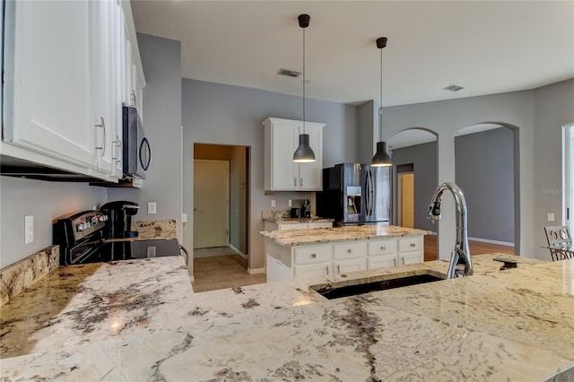 kitchen featuring white cabinetry, light stone countertops, decorative light fixtures, stainless steel appliances, and sink