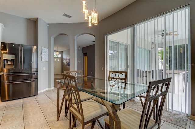 tiled dining room with an inviting chandelier