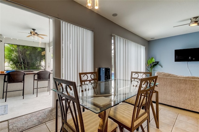 tiled dining space with ceiling fan and a healthy amount of sunlight