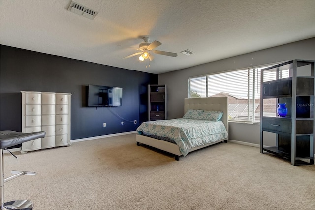 carpeted bedroom featuring ceiling fan and a textured ceiling