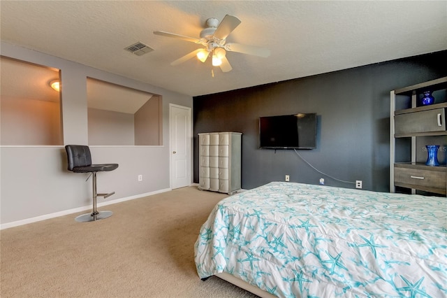 bedroom with ceiling fan, a textured ceiling, and light carpet