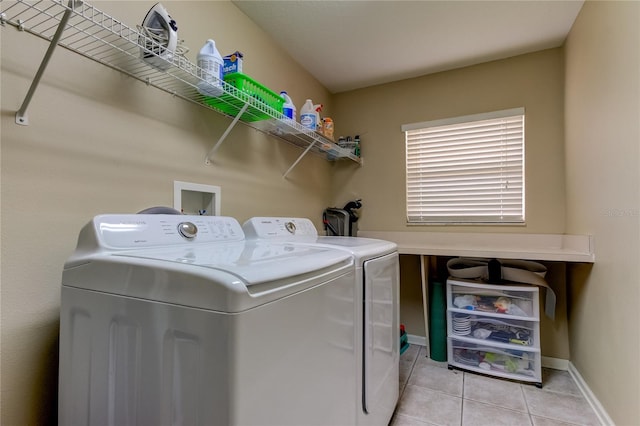 clothes washing area featuring light tile patterned floors and washing machine and clothes dryer