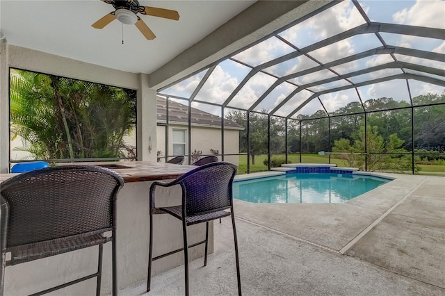 view of pool featuring ceiling fan, a patio area, and a lanai