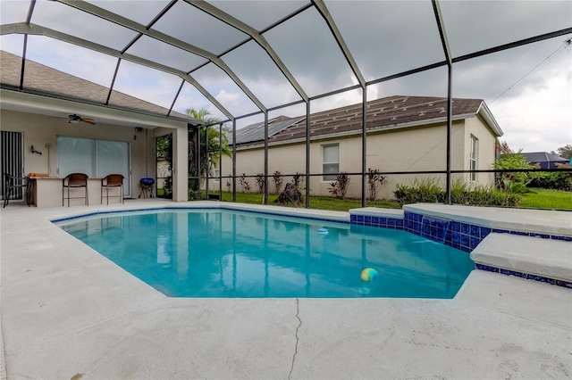 view of swimming pool featuring glass enclosure, ceiling fan, a patio, and pool water feature