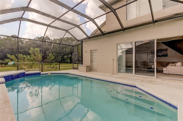 view of swimming pool featuring glass enclosure and a patio