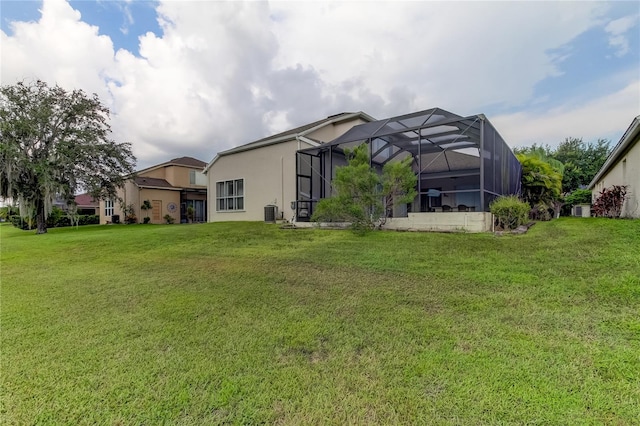 rear view of house with a lanai and a yard