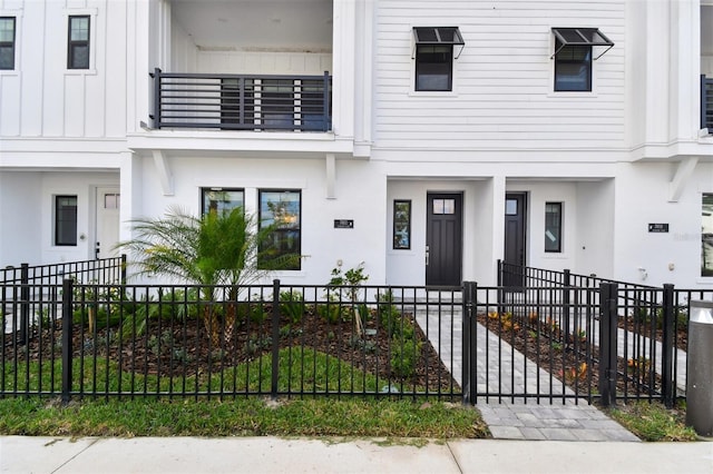 view of property with a fenced front yard and a balcony