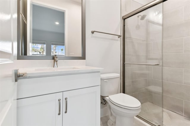 bathroom featuring vanity, toilet, and walk in shower