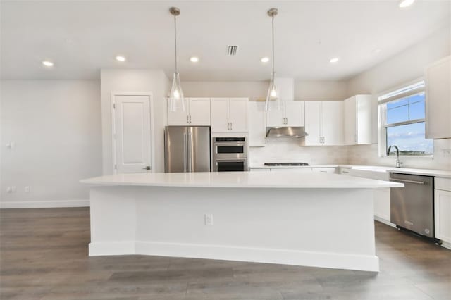 kitchen featuring pendant lighting, a center island, dark hardwood / wood-style floors, appliances with stainless steel finishes, and white cabinetry